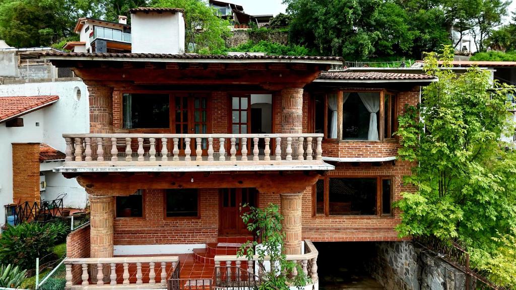 a brick house with a balcony on the side of it at Casa Zaragoza in Valle de Bravo