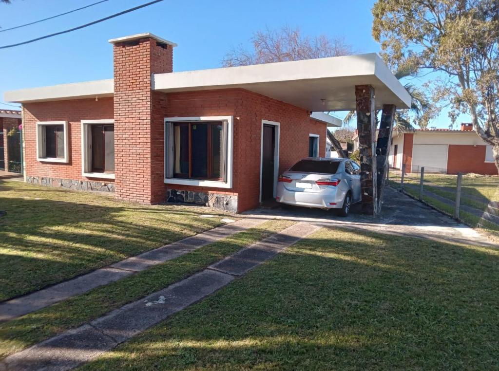 a house with a car parked in front of it at Corbeta in Piriápolis