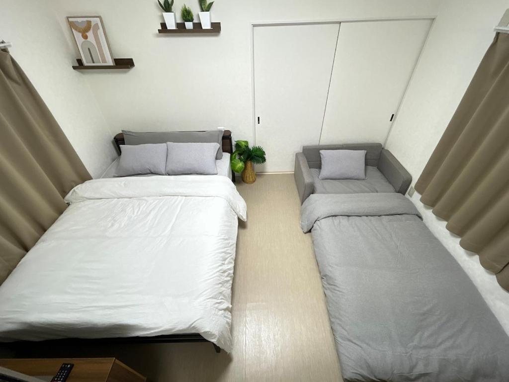 a room with two beds in a room at COMMA House in Yokohama