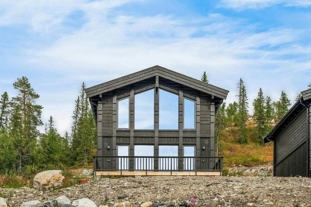 een huis op een heuvel met een groot raam bij Mountain Cabin With Panoramic Views In Norefjell in Runn