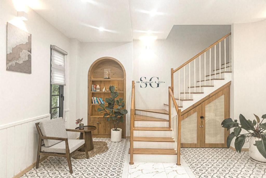 un salon avec un escalier et une chaise dans l'établissement Novaworld Phan Thiết -Villa Nghỉ dưỡng, à Bình Tú