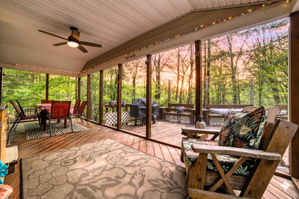 a screened in porch with a ceiling fan at 1mi to Lake Wallenpaupack | Firepit | Pet Friendly in Paupack