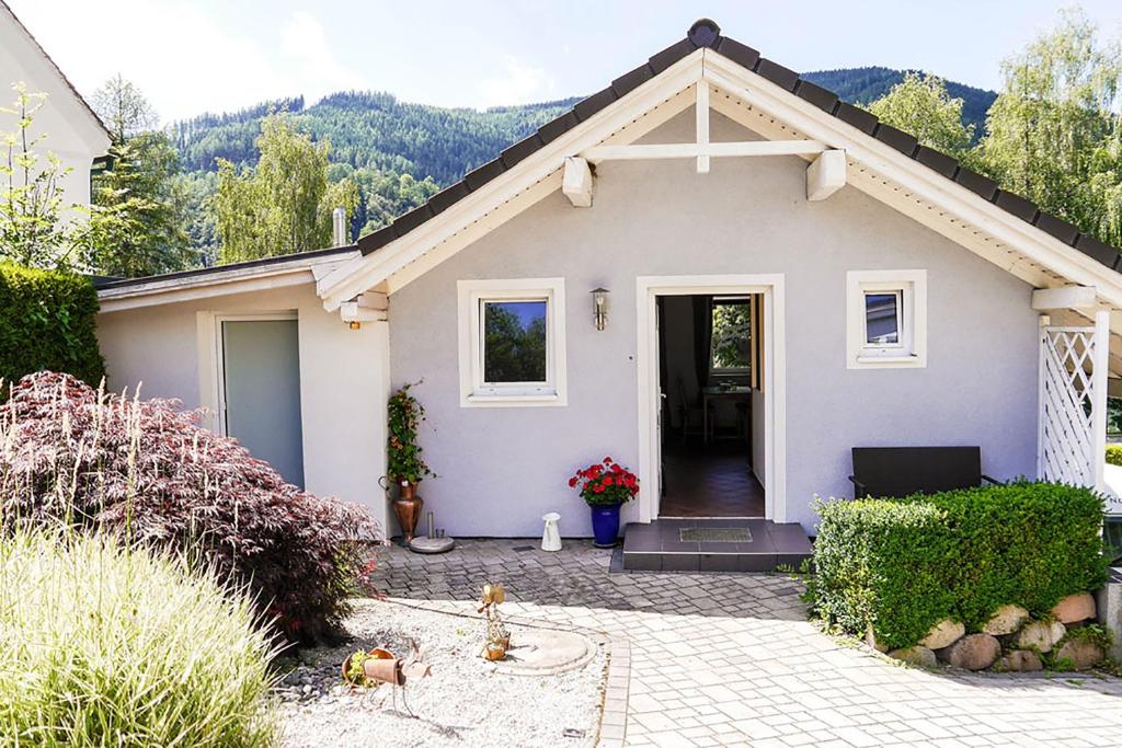 ein kleines weißes Haus mit Auffahrt in der Unterkunft Millenium Inn in Mürzzuschlag