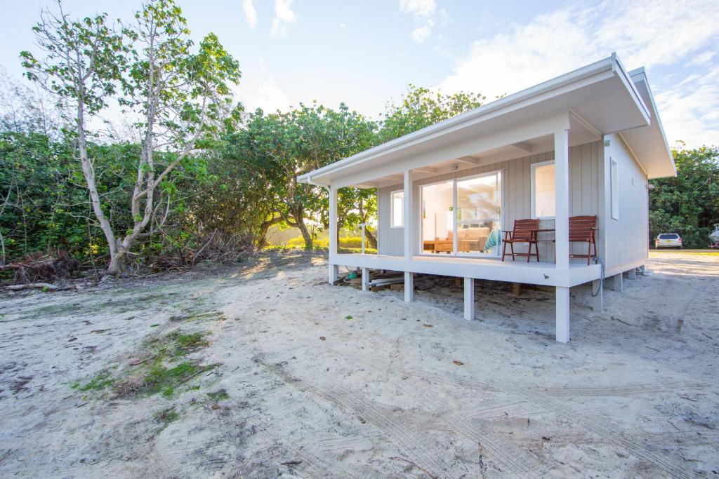 uma pequena casa branca na praia em Frederick and Ngamata's Beach House em Rarotonga