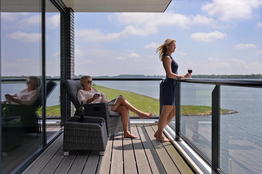 two women sitting in chairs on the deck of a house at Veerse Muze in Kamperland