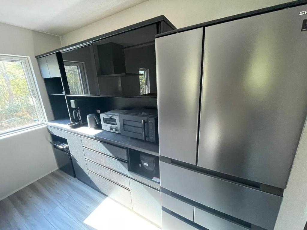 a kitchen with a stainless steel refrigerator at Wakaba Niseko 新築1棟貸切 in Rankoshi