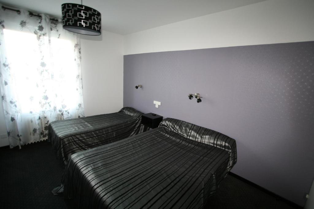 Postel nebo postele na pokoji v ubytování Hôtel Le Picardy