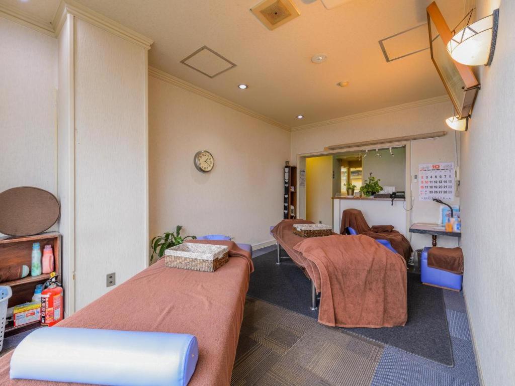 a hospital room with two beds and a mirror at Itabashi Hotel Hilltop in Tokyo