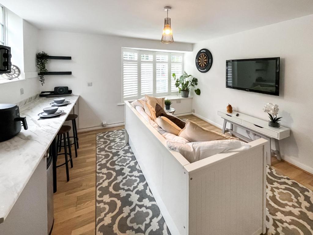 ein Wohnzimmer mit Sofa und Fernseher in der Unterkunft Twin Pines in Kenley