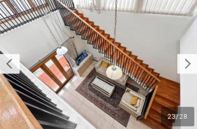 an overhead view of a living room under a staircase at Newly Large Villa 3BR Dago Bandung by 2ndHome in Bandung