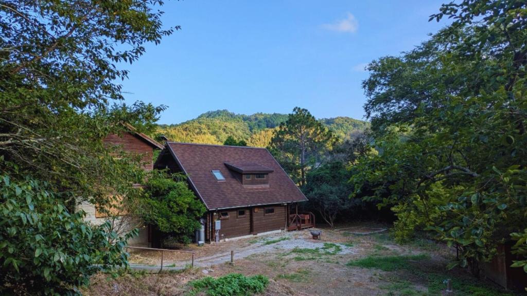 a log cabin in the middle of a forest at 自然豊かな森の中に静かに佇むログハウス #貸別荘 #一棟貸切 #グループ旅行や家族旅行におすすめ #広々吹き抜けリビング #BBQのできるウッドデッキ #ジブリ風空間 #満天の星空 #鋸南 #南房総 #komorebi in Kyonan