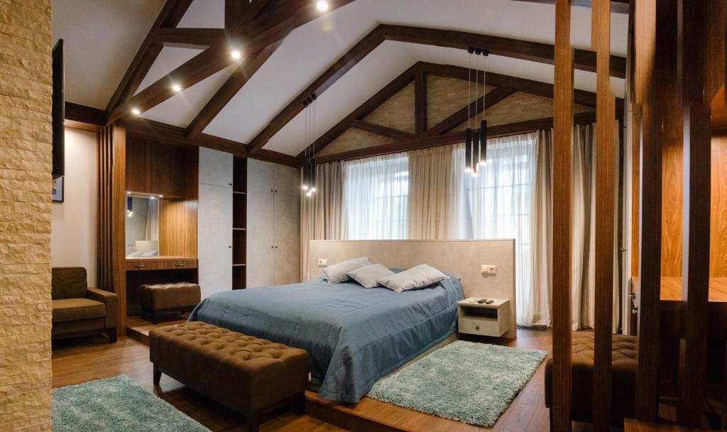 1 dormitorio con 1 cama y 1 silla en una habitación en Petrani Nivki en Kiev