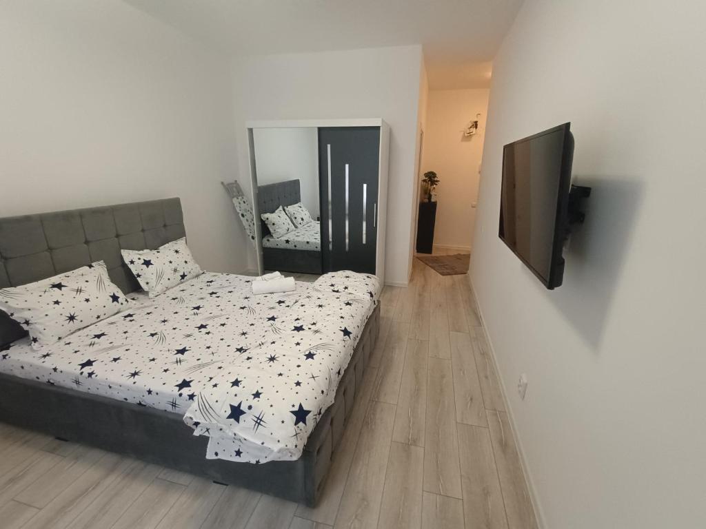 a bedroom with a bed and a flat screen tv at Avangarde House in Chiajna