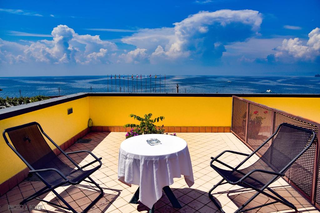 eine Terrasse mit einem Tisch und Stühlen auf dem Balkon in der Unterkunft Hotel Ristorante Miralago in Garda