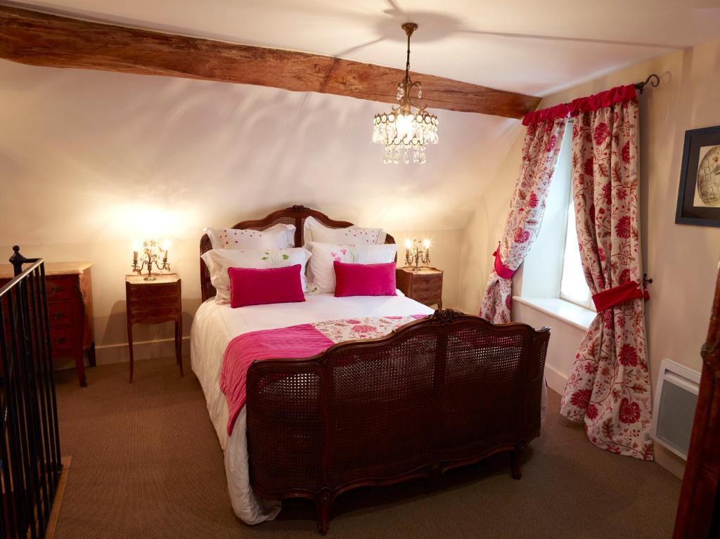 ムルソーにあるChez Hall le Coinのベッドルーム1室(ピンクの枕が付いた大型ベッド1台付)