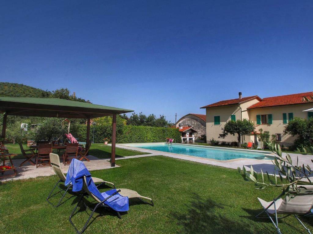 un cortile con sedie e una piscina di Belvilla by OYO Montecchio a Castiglion Fiorentino
