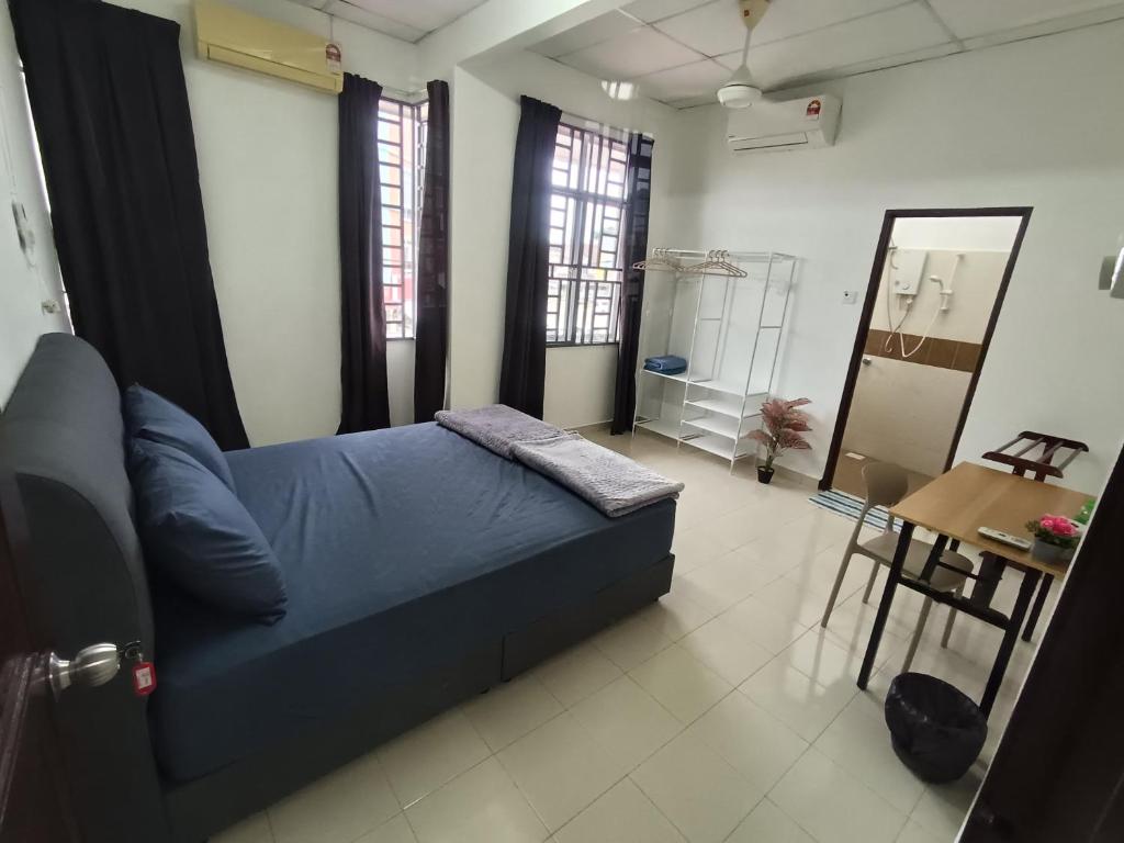 - une chambre avec un lit bleu dans une pièce dotée de fenêtres dans l'établissement Harmoni Homestay R2 Wakaf Tapai ECRL KT Station, à Kuala Terengganu