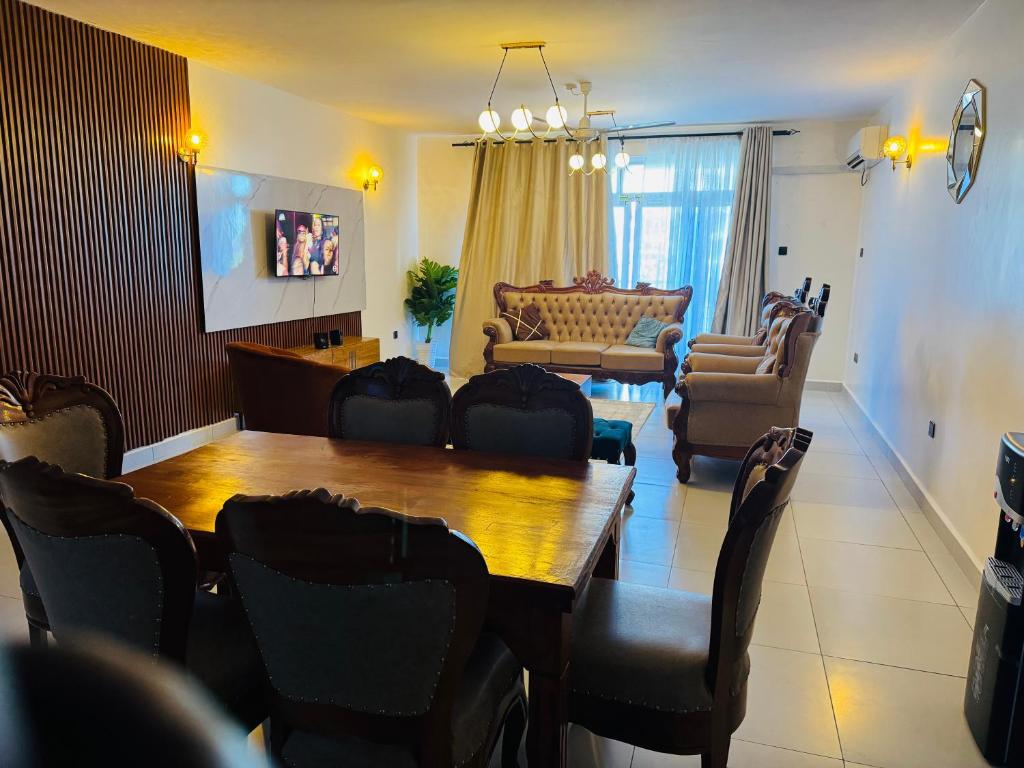 a living room with a wooden table and chairs at Gianas stays Nyali in Mombasa