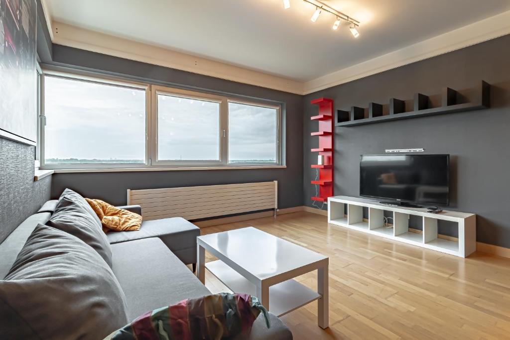 a living room with a couch and a tv at Comfort & Views over Riga Apartment near Airport and City Center in Rīga