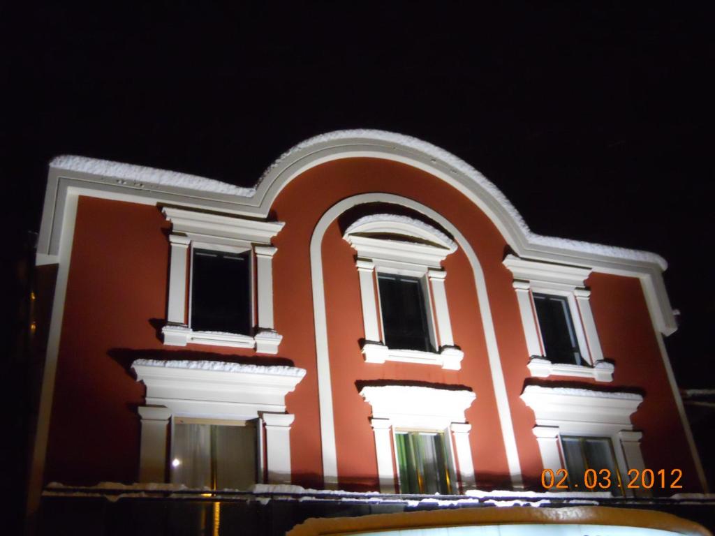 een groot oranje gebouw met witte zuilen en ramen bij Hotel Val Di Sangro in Perano