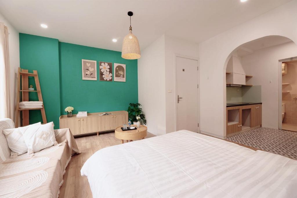 a bedroom with a white bed and a green wall at Fuji Hanoi Hotel and Apartment West Lake in Hanoi