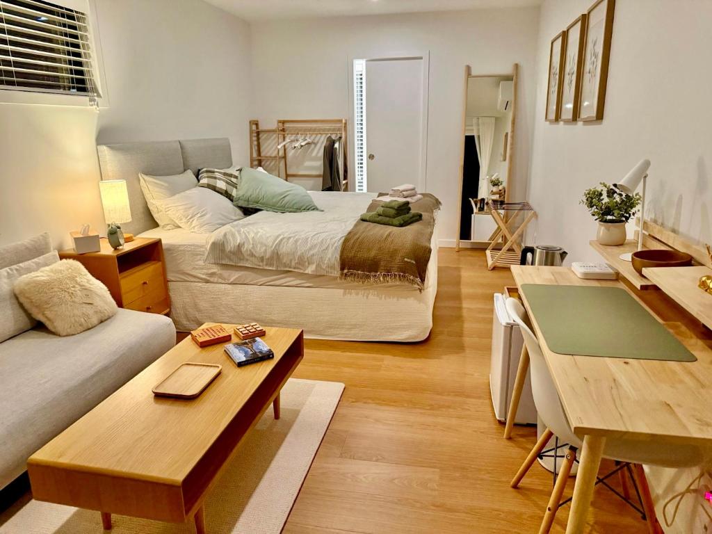 a living room with a bed and a couch at The Mann Homestay, Premium King Room with Private Ensuite, Near Waihi & Coromandel in Waihi