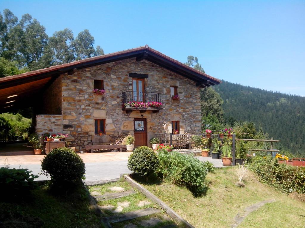 a stone house with flowers in front of it at Dukebaso in Durango