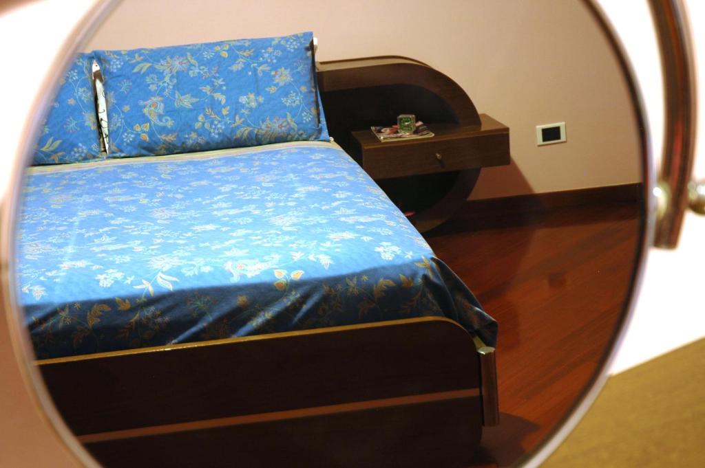 Liana Guest House في ألغيرو: مرآة تعكس سرير في غرفة النوم
