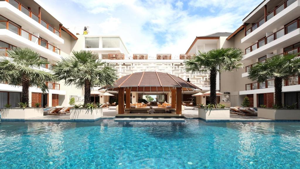 a swimming pool with a gazebo in front of a hotel at The Bandha Hotel & Suites in Legian