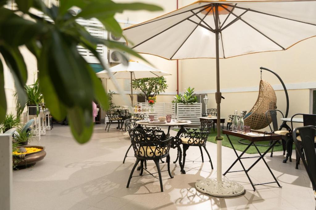 a restaurant with tables and chairs and an umbrella at Broadway An Alivaa Collection Hotel, near Connaught Place in New Delhi