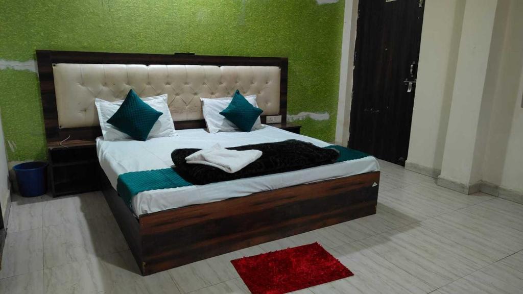 una camera da letto con un letto grande con pareti verdi di Hotel O Rana Guest House a Ballabgarh