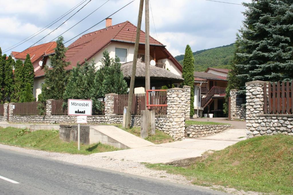 uma casa com uma vedação e um cartaz à frente dela em Horváth Vendégház em Mónosbél