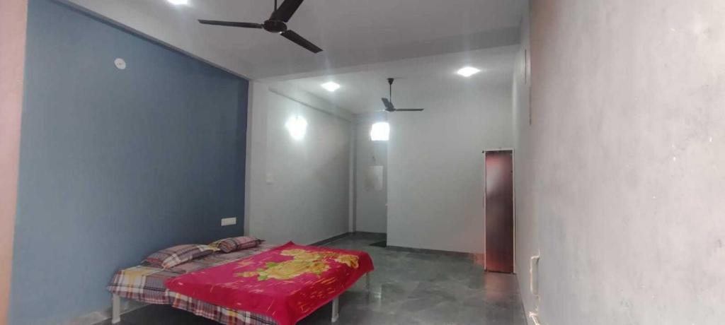 a bedroom with a bed with a ceiling fan at Hotel O Sangam Gardan in Sipra