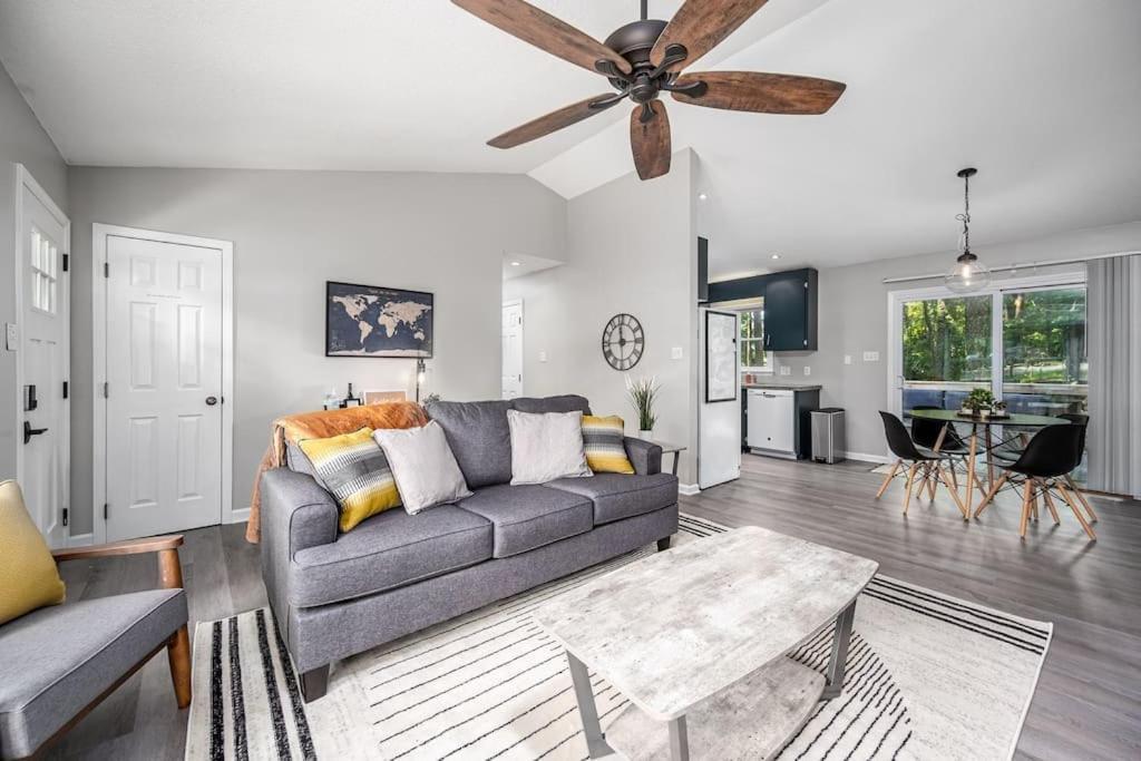 a living room with a couch and a ceiling fan at Cozy on Ger Maine St 1 Mile From Downtown Apex in Apex