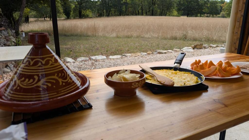 a table with a bowl of food and a plate of food at Le chalet du bien-être in Vailhourles