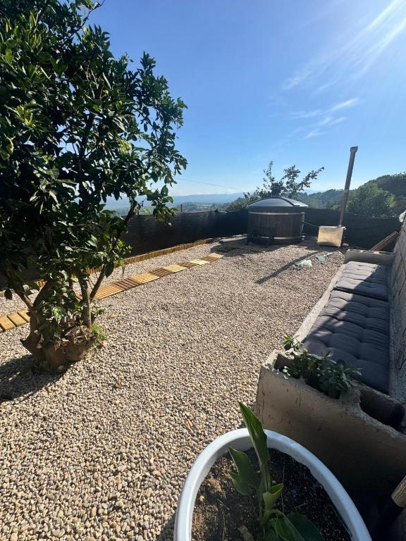 a gravel garden with a tree and a building at Casa en la montaña con jacuzzi exterior y piscina in Alcántara de Júcar