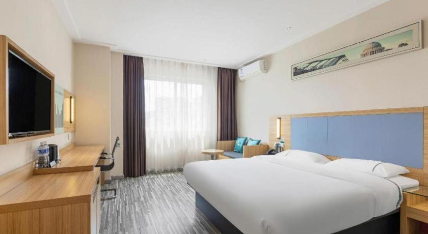 une chambre d'hôtel avec un grand lit et une télévision dans l'établissement City Comfort Inn Dongguan Nancheng Tian'an Digital City, à Dongguan