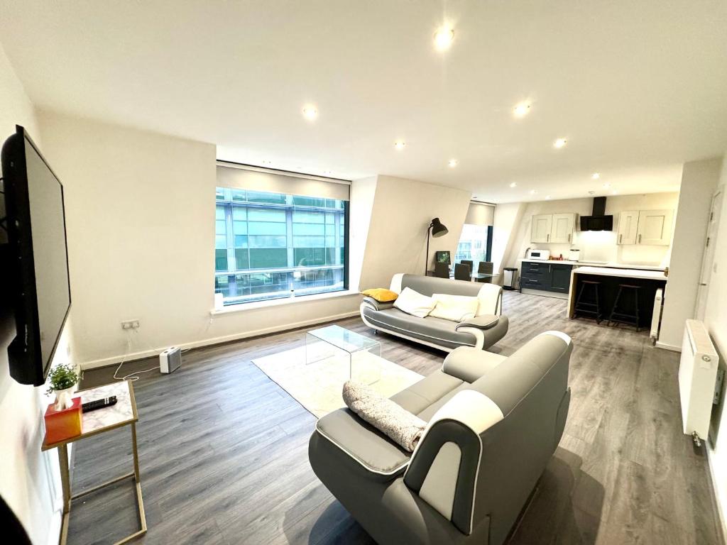 a living room with two couches and a kitchen at Best Location, Luxury, 2 to 8 guest, SkyTV and More in Liverpool