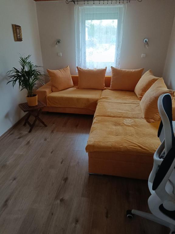 a living room with a couch and a window at Kerka Szállás in Kerkabarabás
