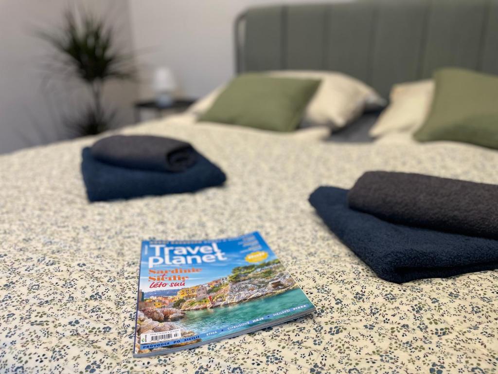 a book sitting on top of a table with two beds at Atlas suites WEST in Košice