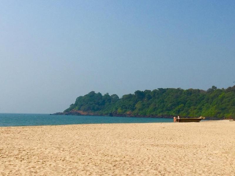 a boat sitting on a beach next to the water at Shree's Seaside Homestay - Sea Pearl in Magdāl