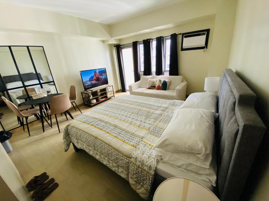 une chambre avec un grand lit et un salon dans l'établissement Manhattan Plaza Tower 1, Araneta City Cubao, Quezon City, Metro Manila, à Manille