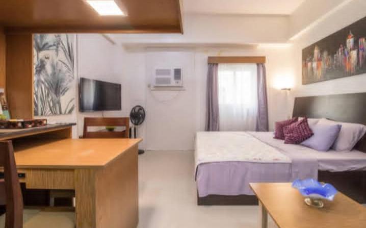 a hotel room with a bed and a desk at Pagusara's Entire Home Vacation in Cebu City