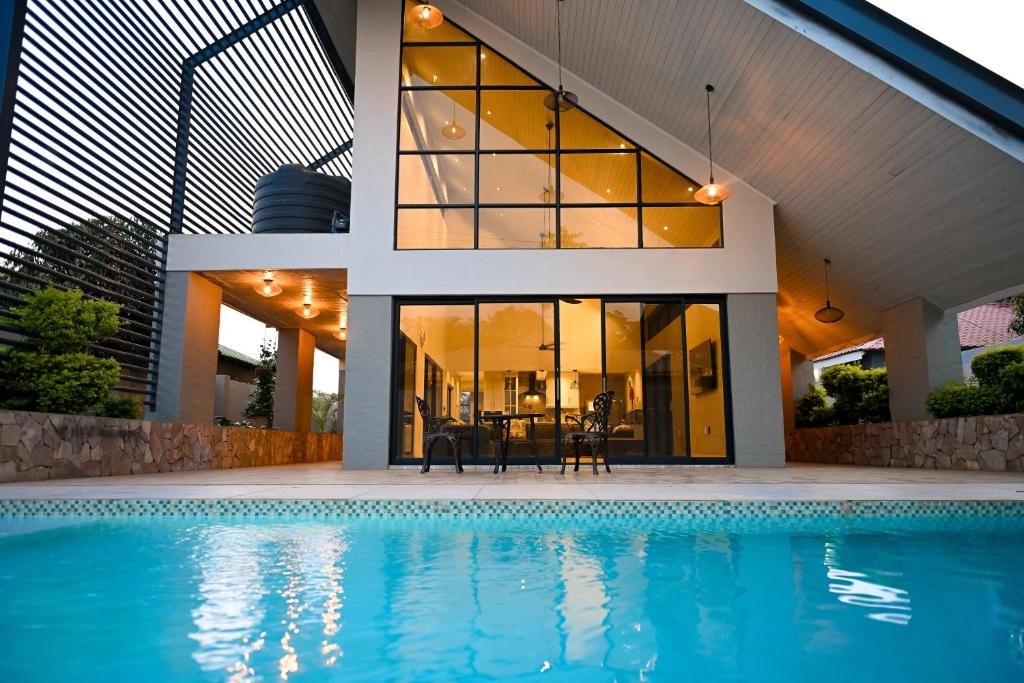 a house with a swimming pool in front of a house at Modern spacious 4-bedroom home in Victoria Falls