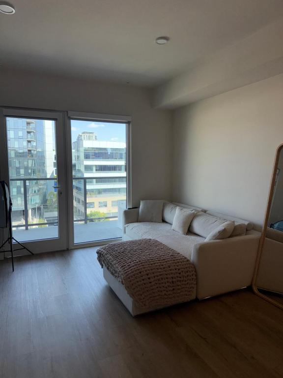 ein Wohnzimmer mit Couch und großem Fenster in der Unterkunft Elevated Escape Luxury 1BR in Hollywood in Los Angeles