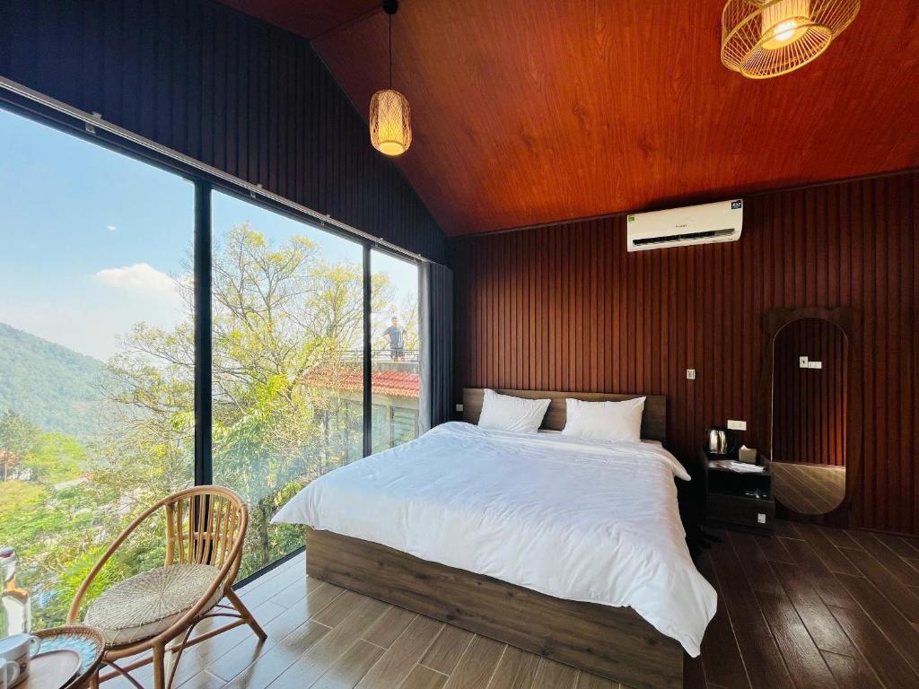a bedroom with a large bed and a large window at Hola Homestay in Tam Ðảo