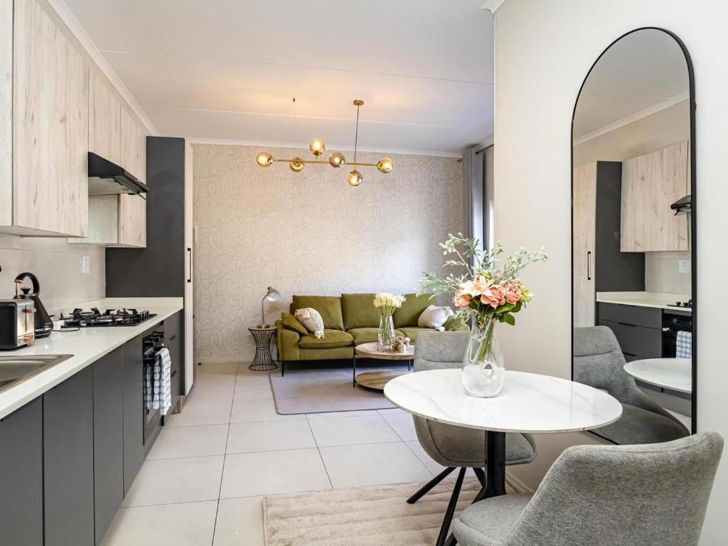 a kitchen and living room with a table and a couch at The Sweet Serenity Suite in Midrand