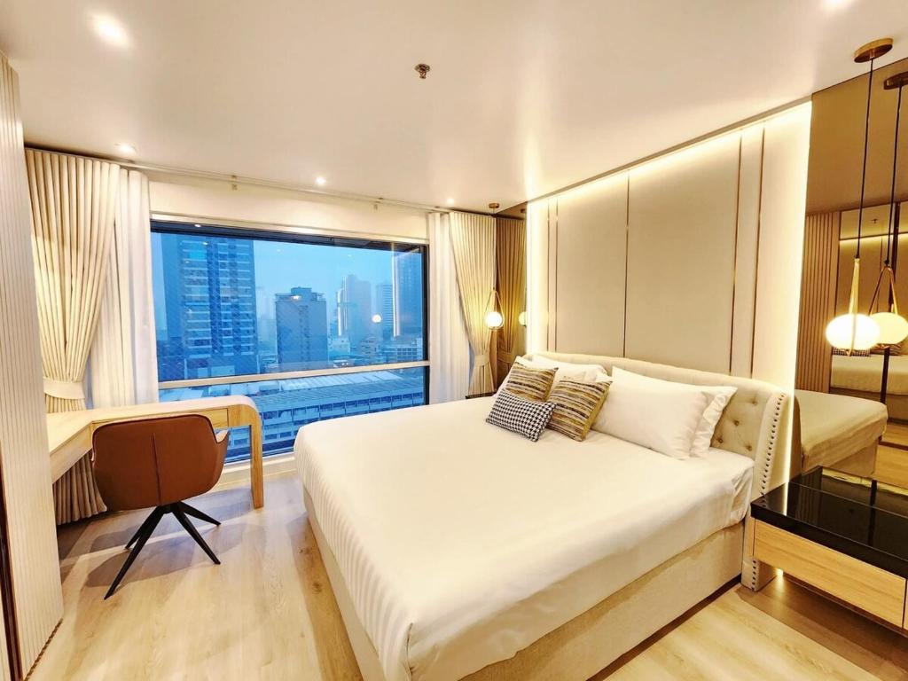 Una cama o camas en una habitación de คอนโดสุขุมวิทสวีท เรียบหรู อบอุ่น ครบครัน