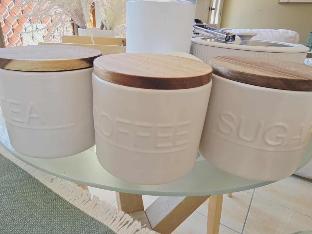 three white pots sitting on a glass table at Beautiful Holiday Home in Gold Coast