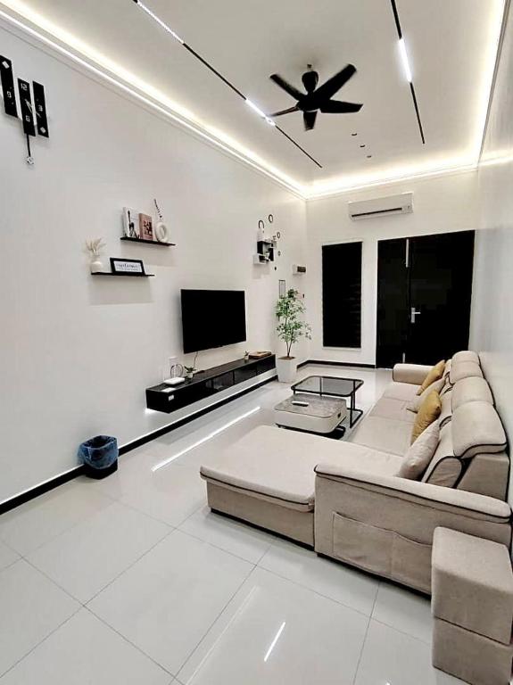 a living room with a couch and a flat screen tv at Taiping CreekLodge - Modern BrandNew HomeStay in Kamunting